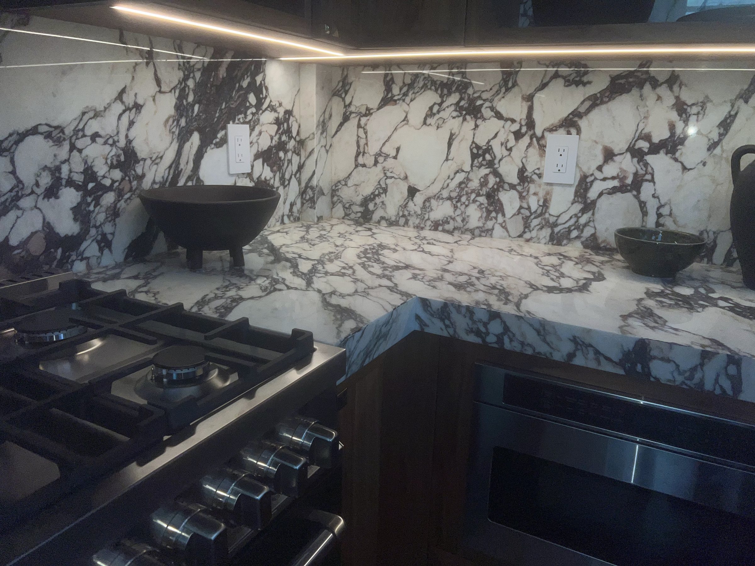Calacatta Viola marble backsplash and waterfall counter above a black range