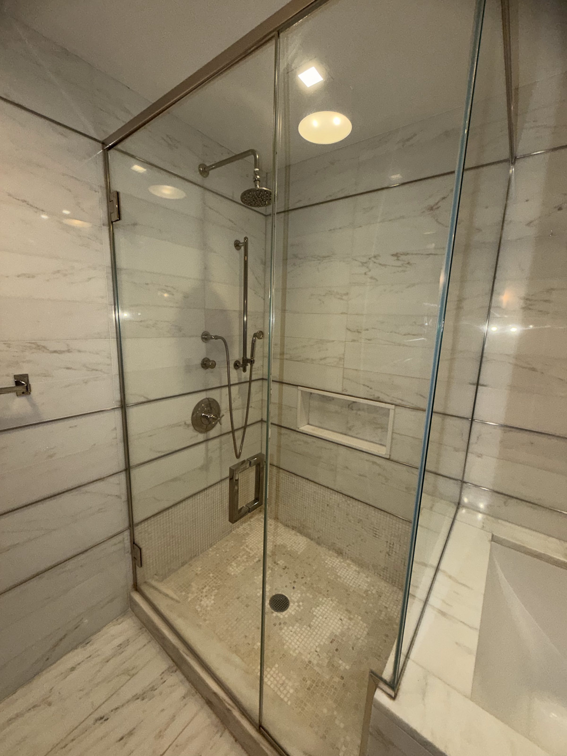 Freestanding tub set beneath an arched niche with timber shelving